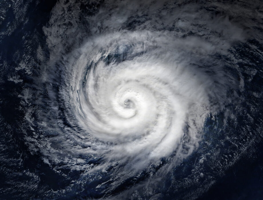 Over the Atlantic Ocean, hurricane eye centered, tight spiral clouds, daytime light, editorial travel photo, no people.