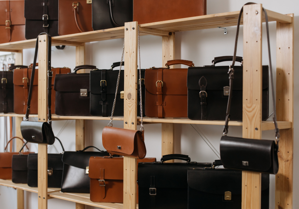 Store interior, leather bags and briefcases, orderly shelves, soft ambient light, editorial travel photo, no people.